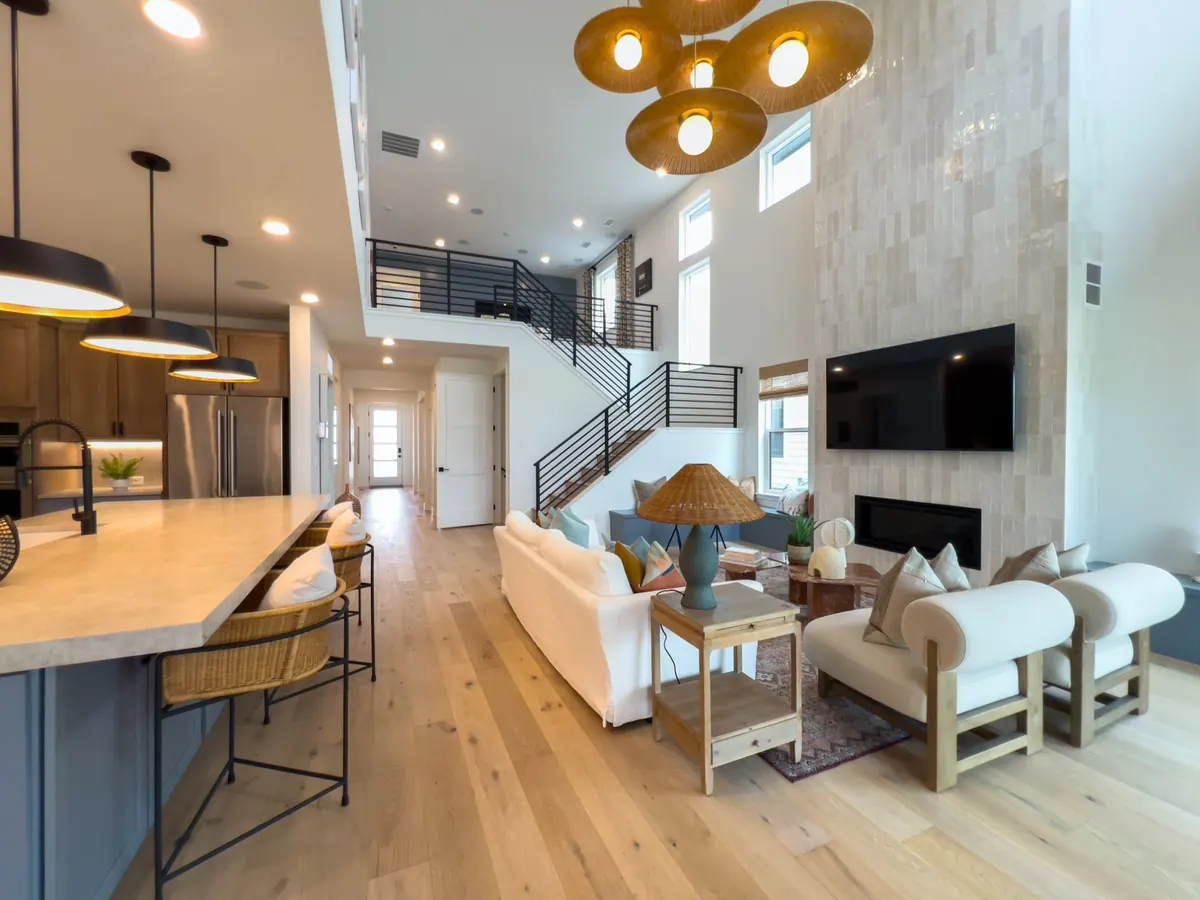 Interior amplio y luminoso de una casa con cocina, sala y doble altura