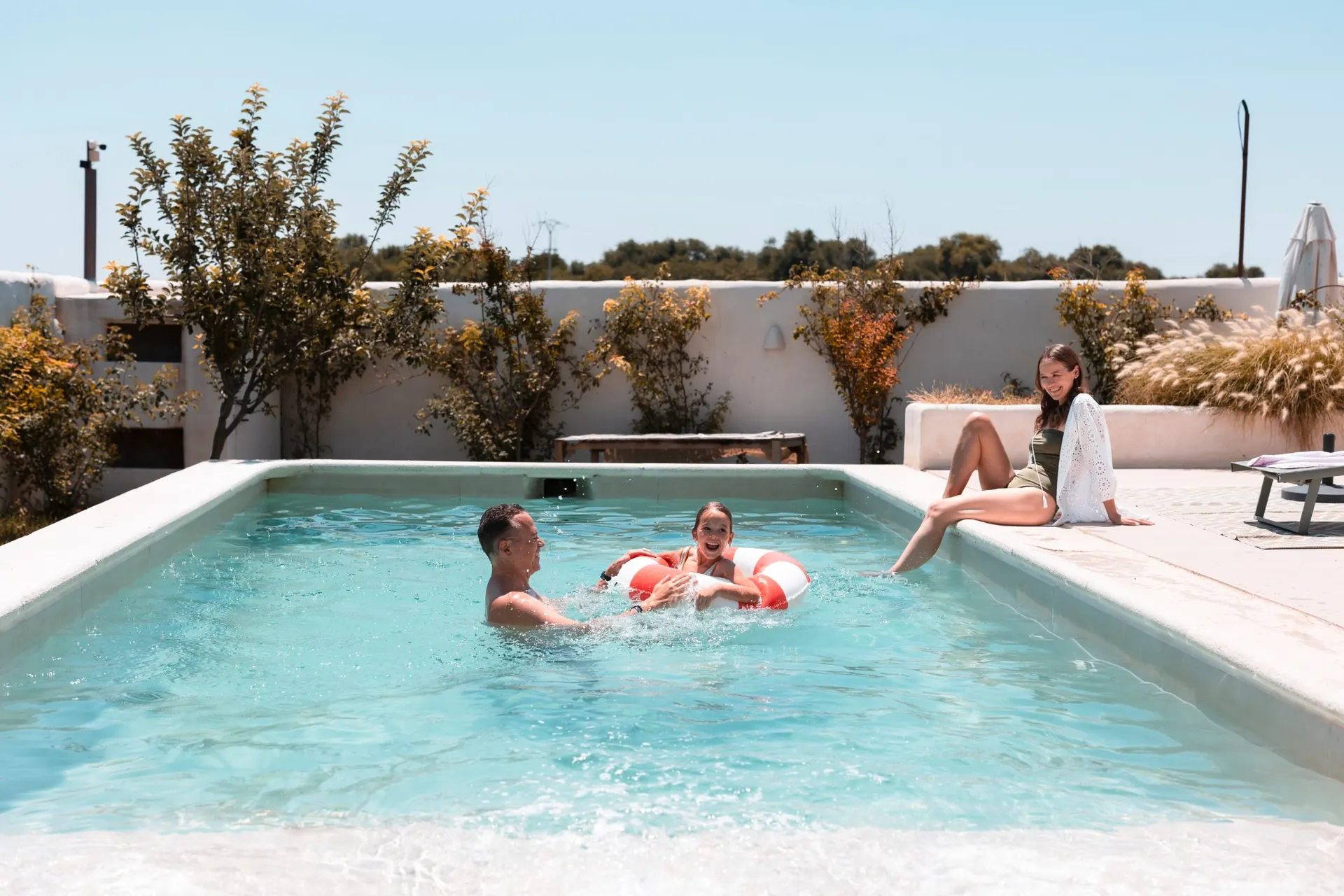 Familia jugando en la piscina de una casa en Nosara